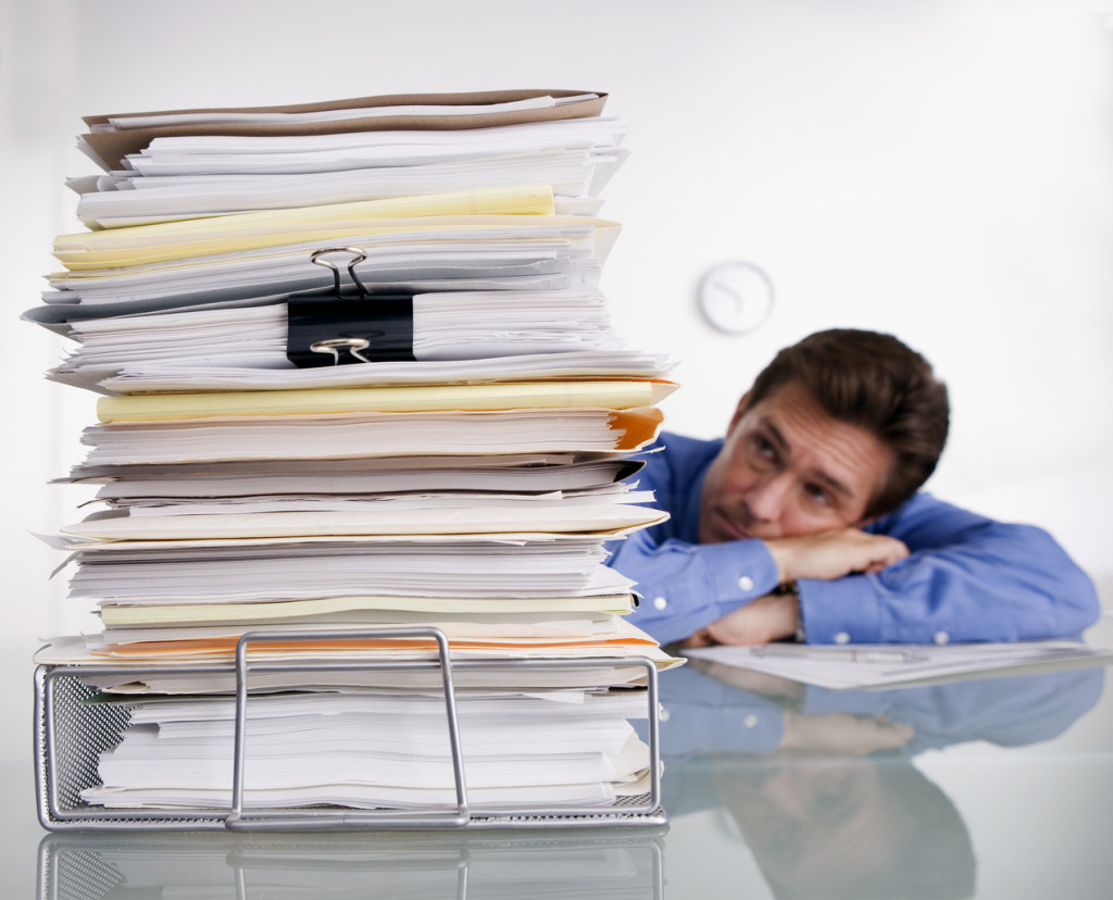 Businessman Overwhelmed with Paperwork --- Image by © Royalty-Free/Corbis